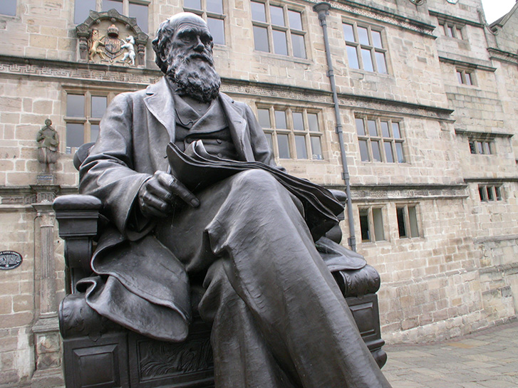 A statue of Charles Darwin in front of the Shrewsbury Library.