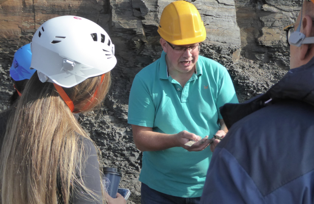 Identifying a fossil, Kimmeridge Bay, Dorset.