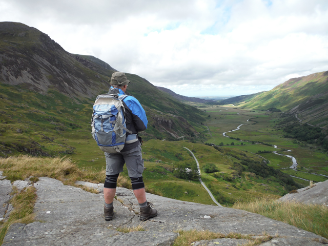 Michael Roberts stands with his back to the camera admiring a beautiful valley in Wales.