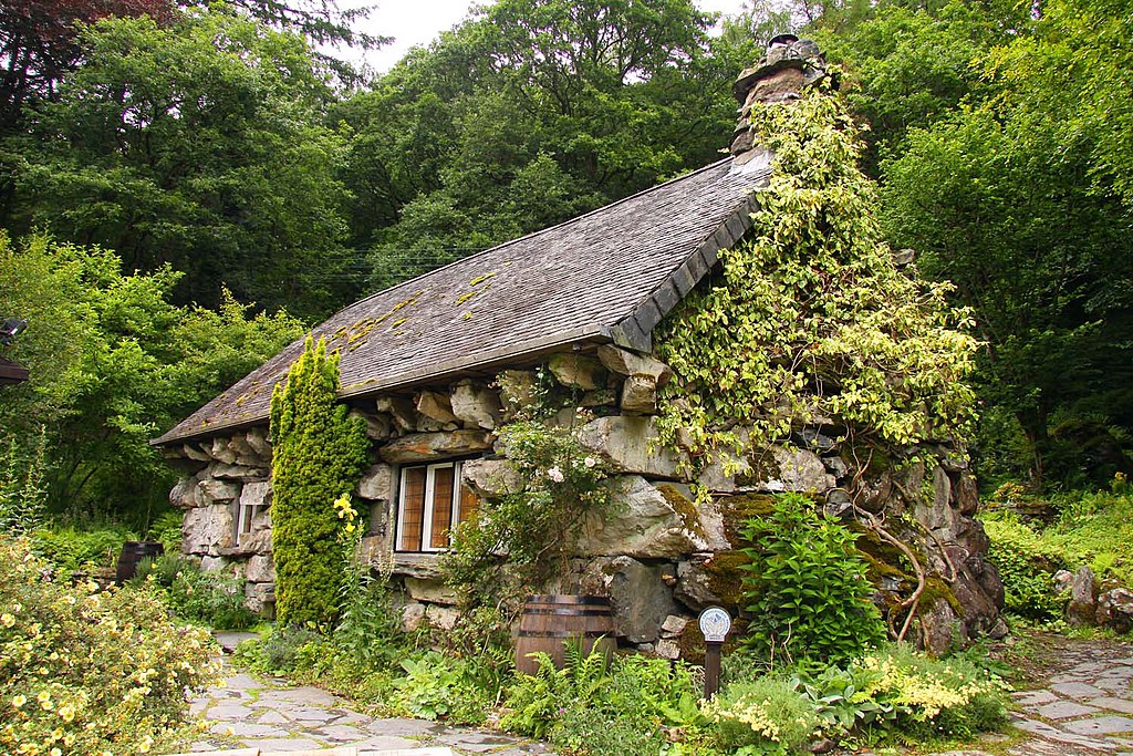The Ugly House in summer - a small building made of enormous stones.